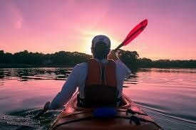 man kayaking on water in seat