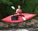 a woman carring a red kayak