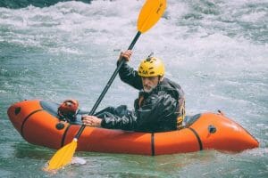 a man in an inflatable kayak in rapids