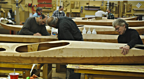 A group of people working on a DIY kayak.