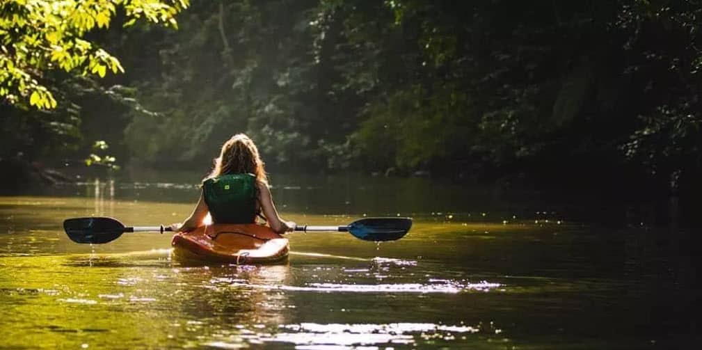 girl kayaking on lake