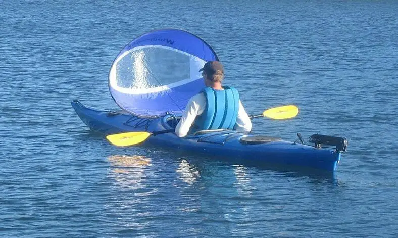 man with kayak sailing