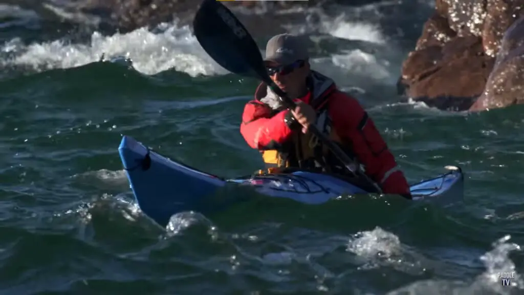 man paddling thru the waves